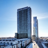 Image of The MET condo tower in Vaughan, Ontario against a blue sky background