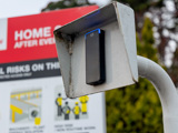 Access reader on pole with sign in background